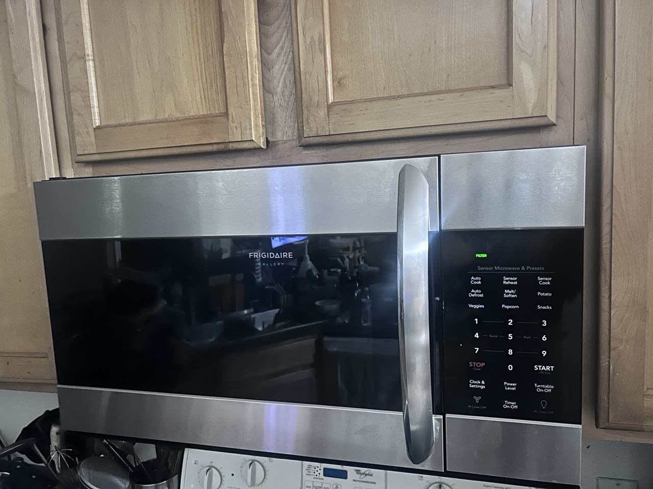 Completed over-the-range microwave installation beneath kitchen cabinetry